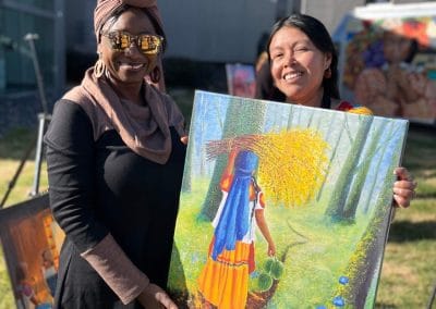 Foto de dos artistas incluyento Norma Martinez, Norma Nahua mostrando su arte.