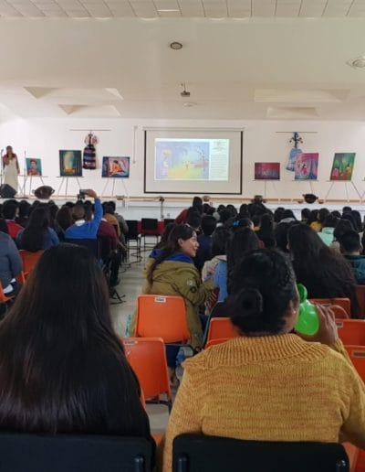 Foto en Auditorio de Norma Martinez dando una presentacion de sus pinturas de arte Nahua