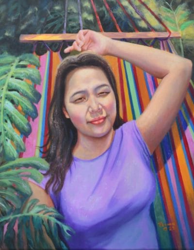 Joven Rebecca acostada en una amaca portando una blusa morada con su pelo suelto.