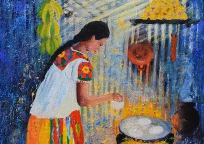 Mujer indijena en frente de un comal calentado a leña torneando tortillas en un comal.