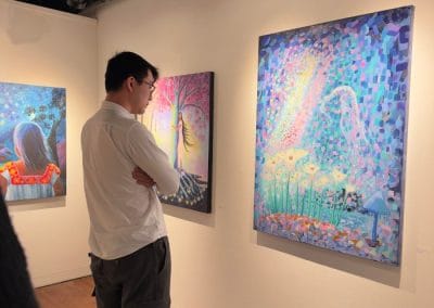 Man observing colorful abstract paintings